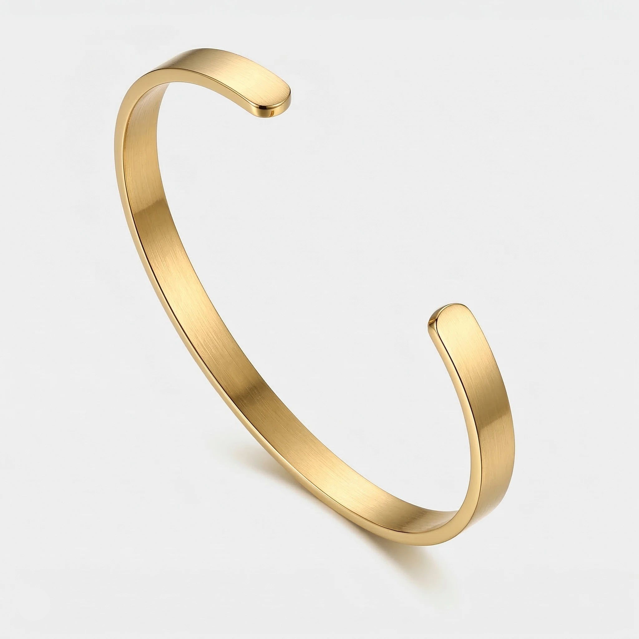 Gold thin cuff bracelet on a light gray background