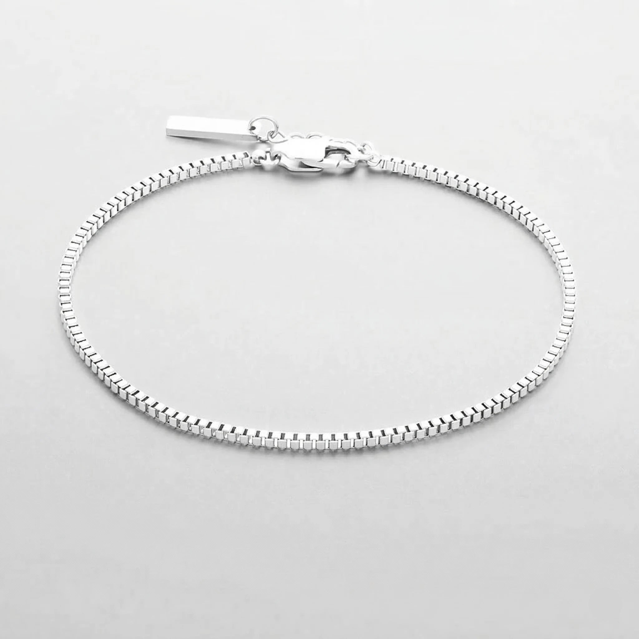 Silver box chain bracelet on a light gray background