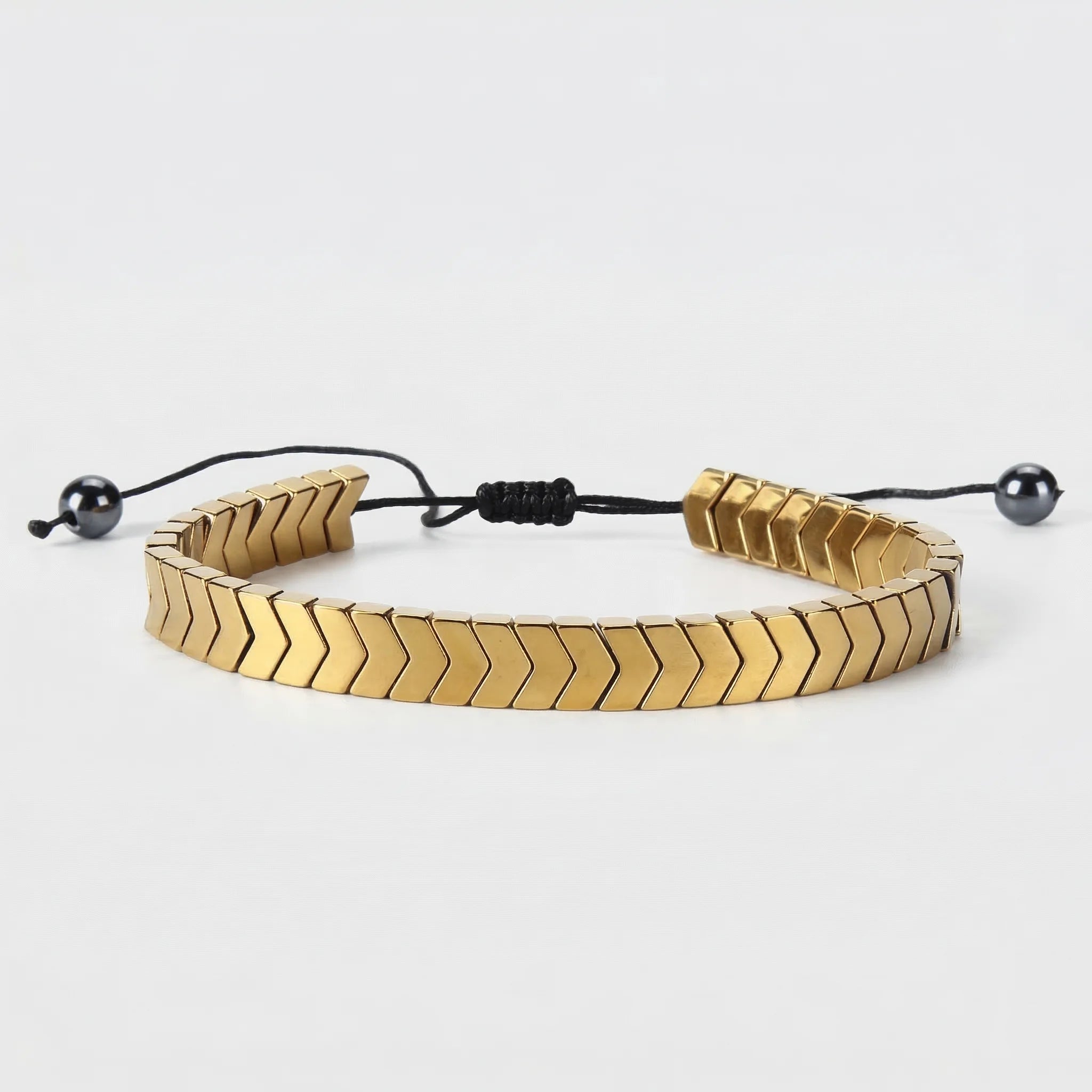 Gold bracelet with a braided pattern on a white background
