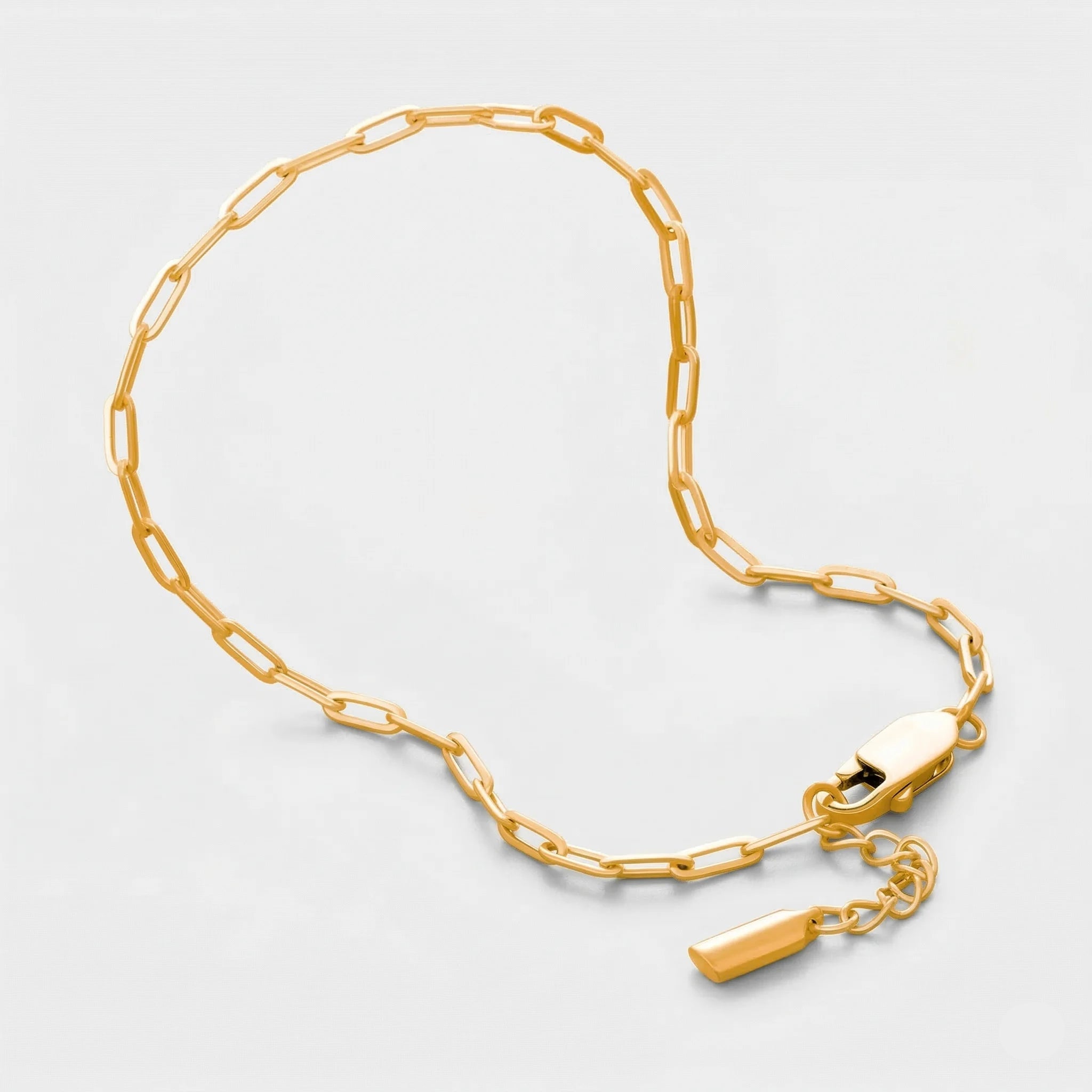 Gold clip chain bracelet on a light gray background