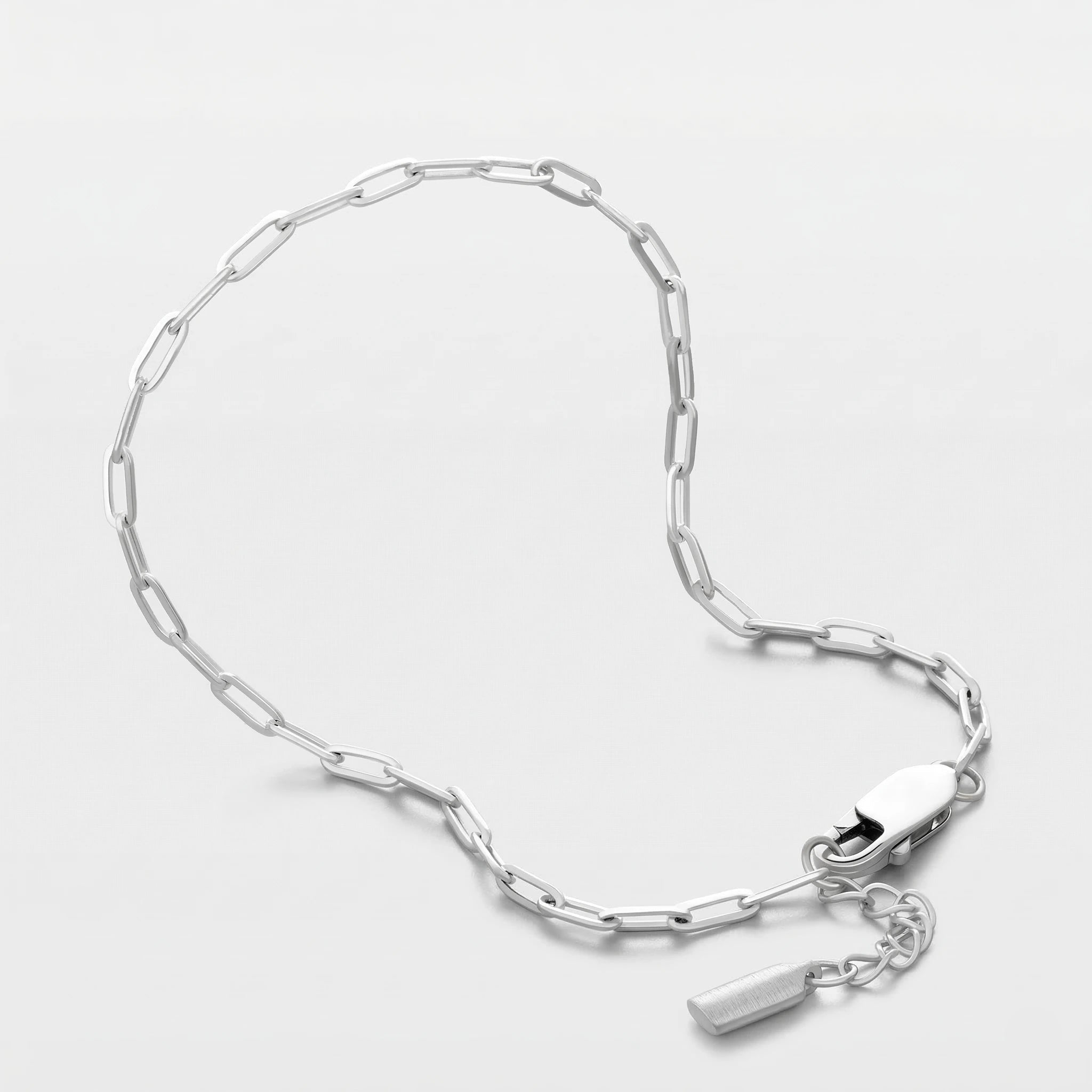 Silver clip chain bracelet on a light gray background