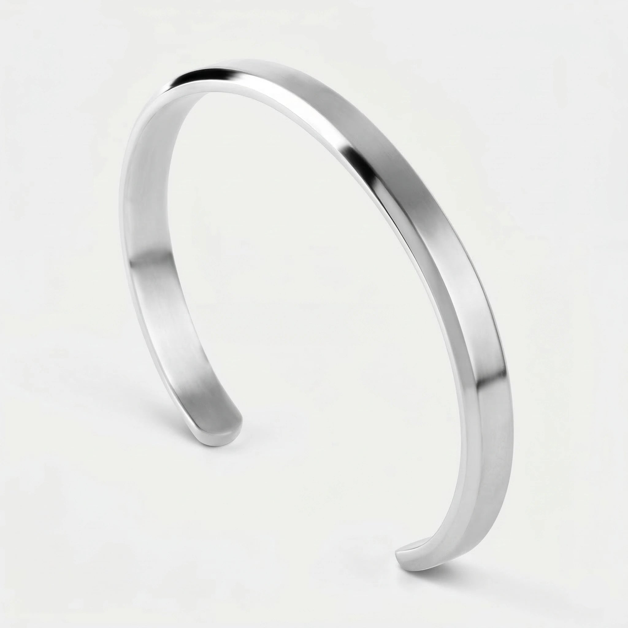 Silver cuff bracelet on a light gray background