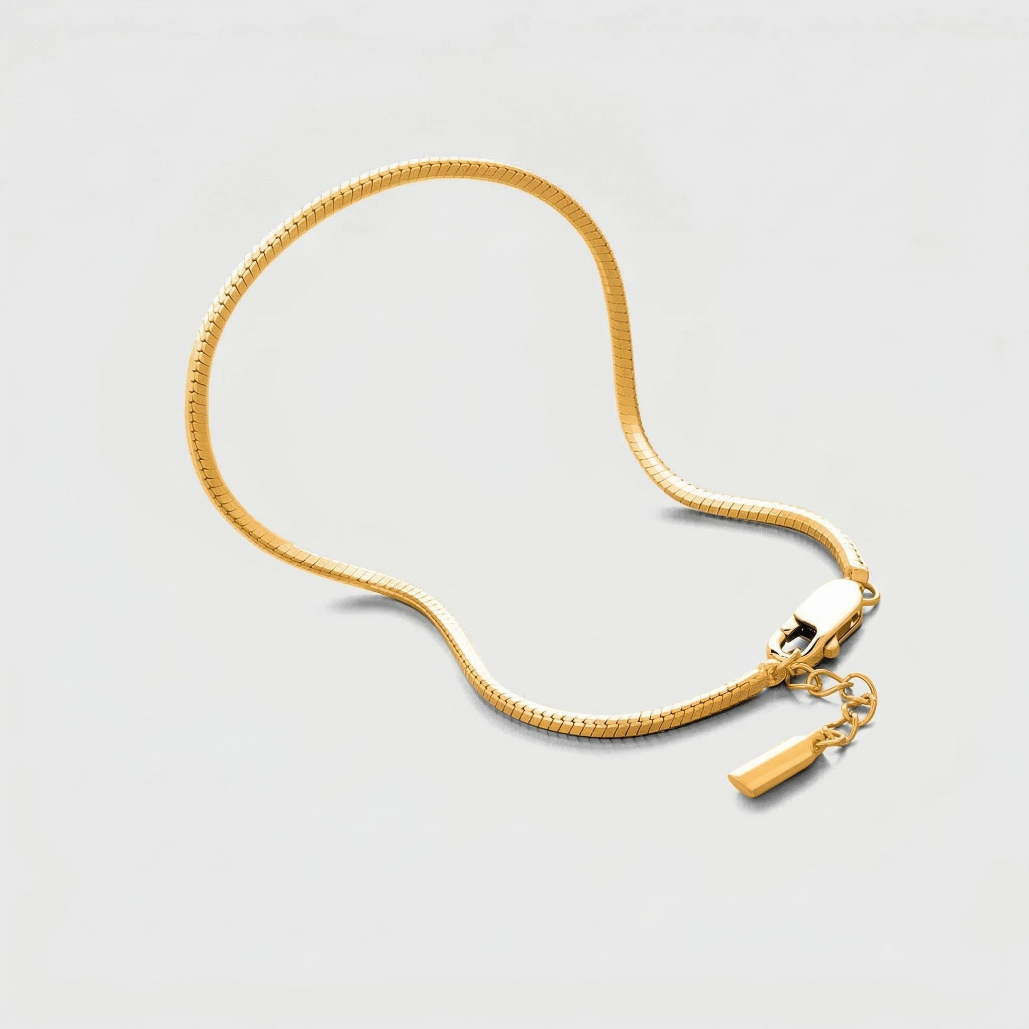 Gold actagonal bracelet on a light gray background
