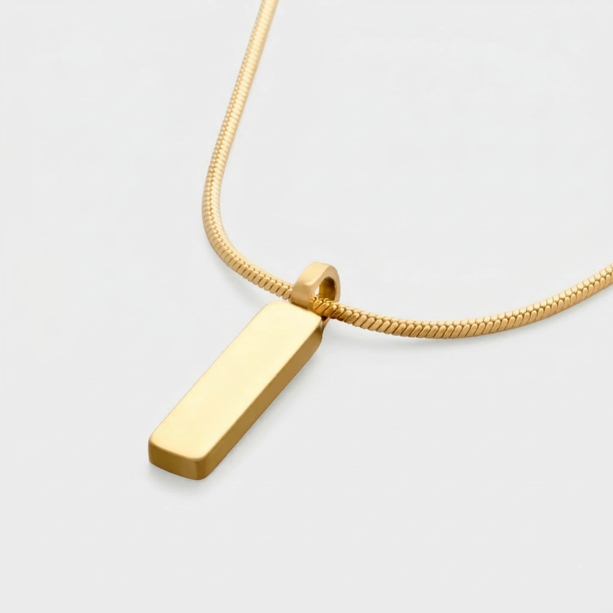 Gold pendant necklace on a light gray background