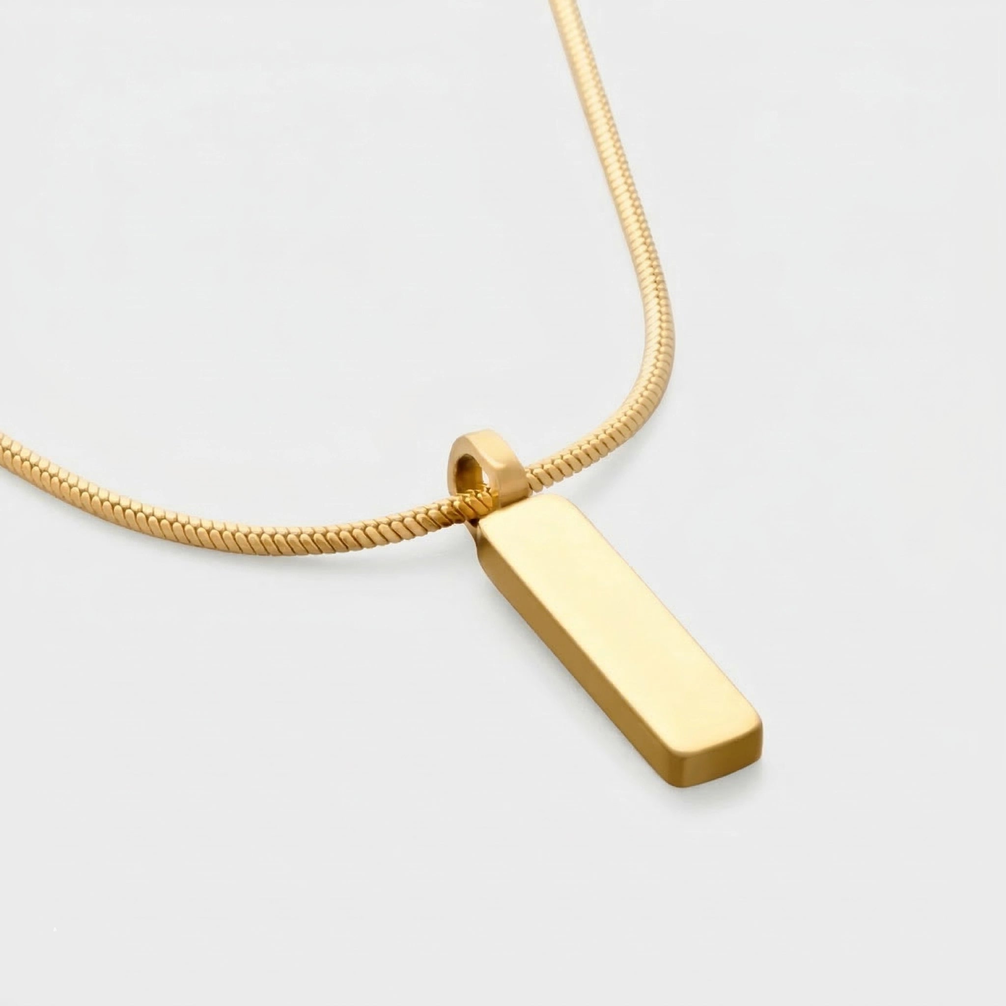 Gold pendant necklace on a light gray background