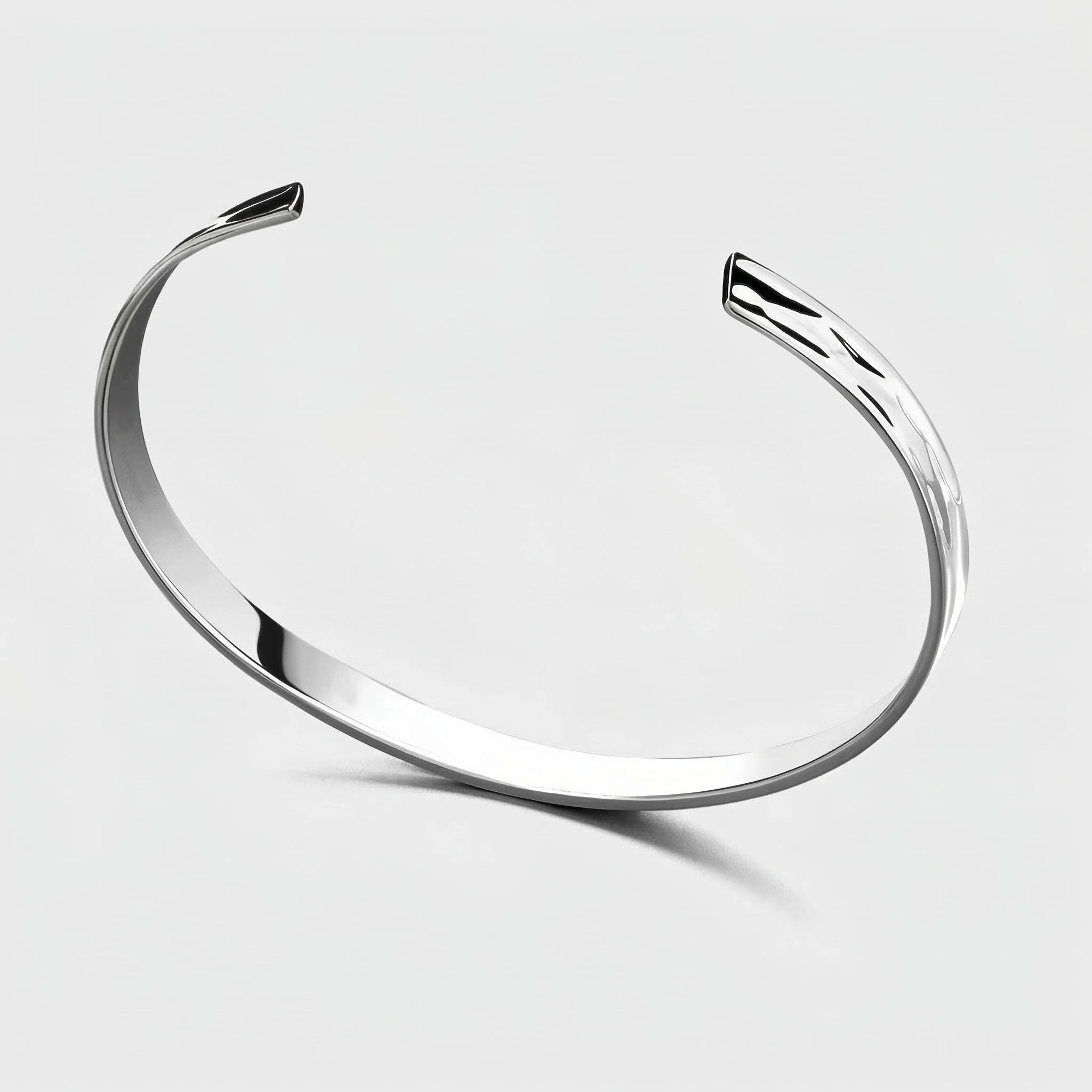 Silver tidal curve bracelet on a light gray background