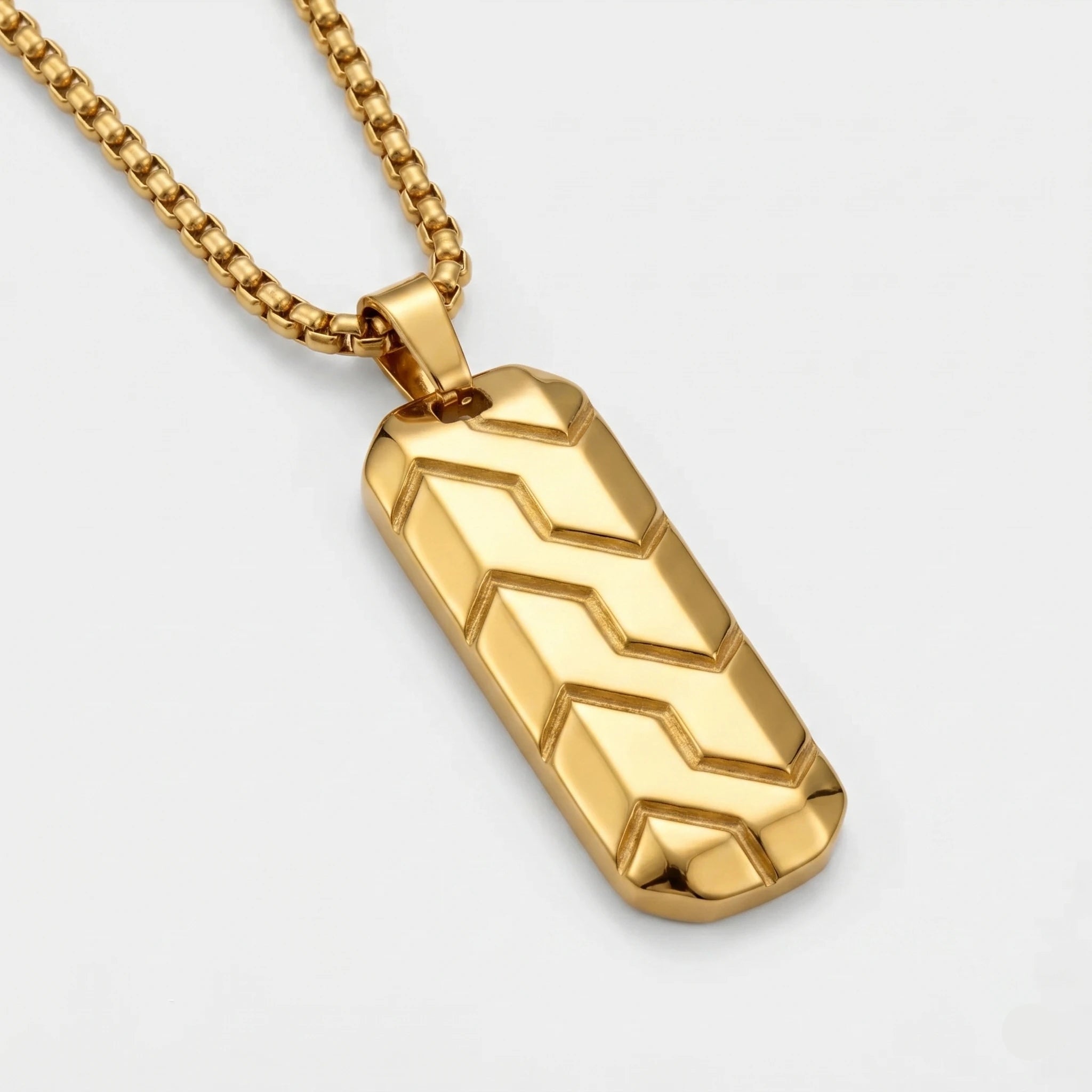 Gold pendant necklace with chevron pattern on a light gray background