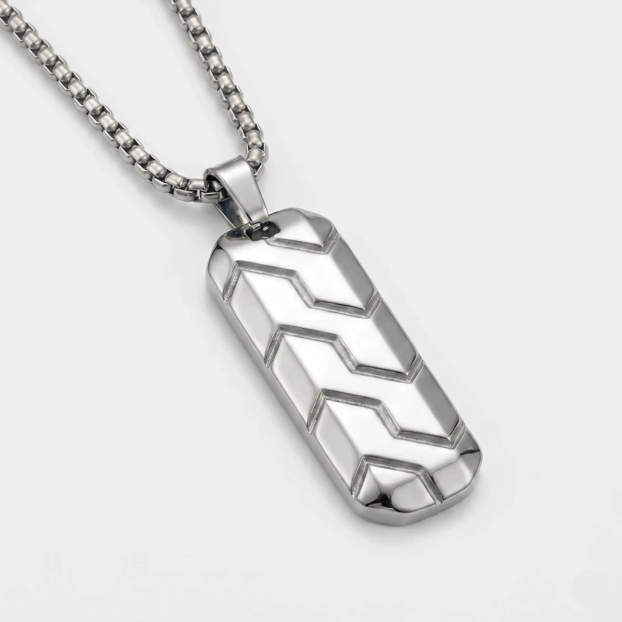 Silver geometric pendant necklace on a light gray background