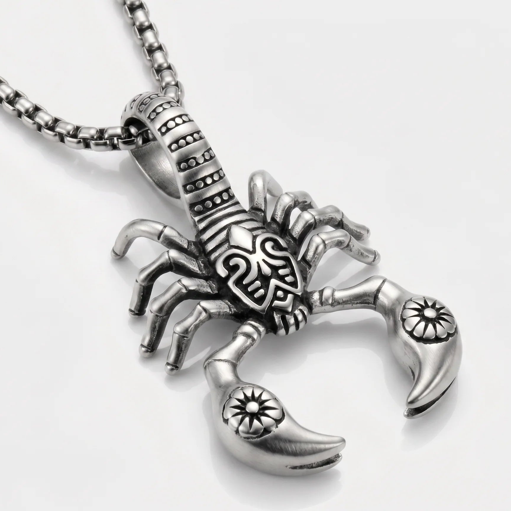 Silver scorpion pendant on a chain against a white background