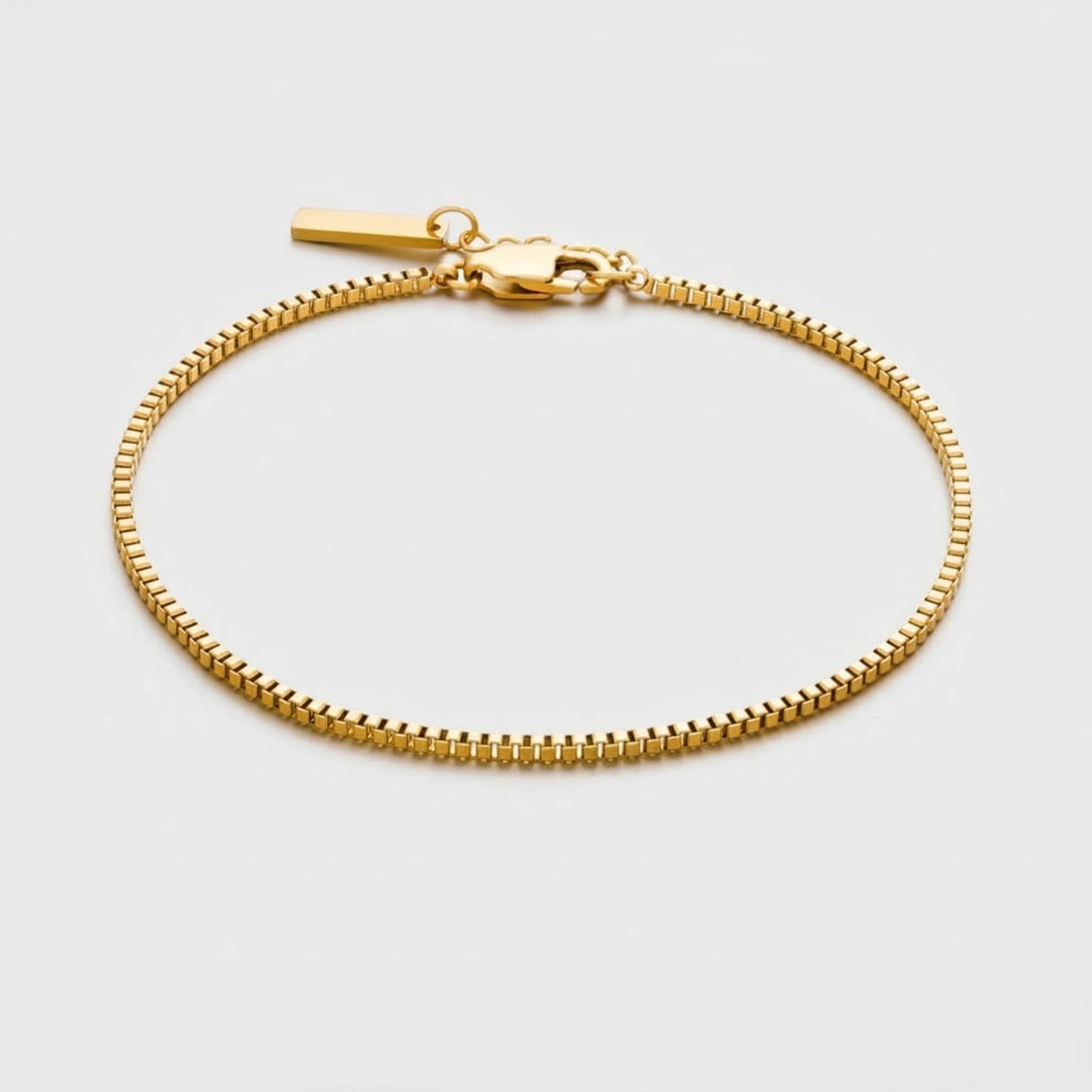 Gold box chain bracelet on a light gray background