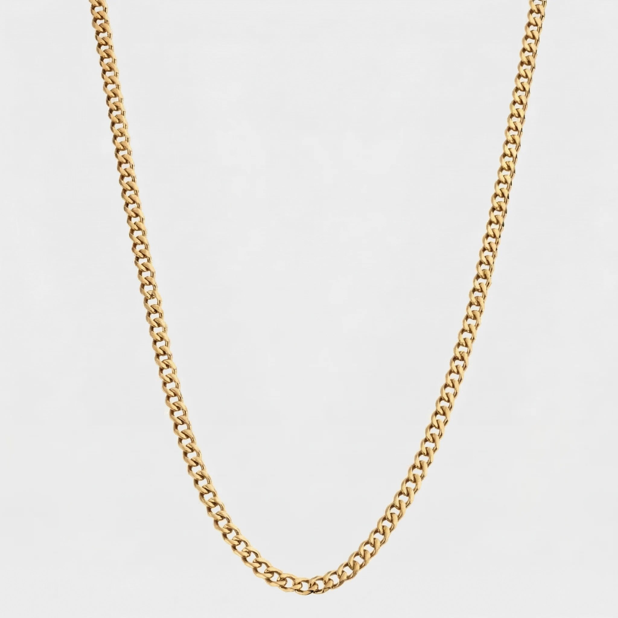 Gold Cuban chain, 3mm on a light gray background