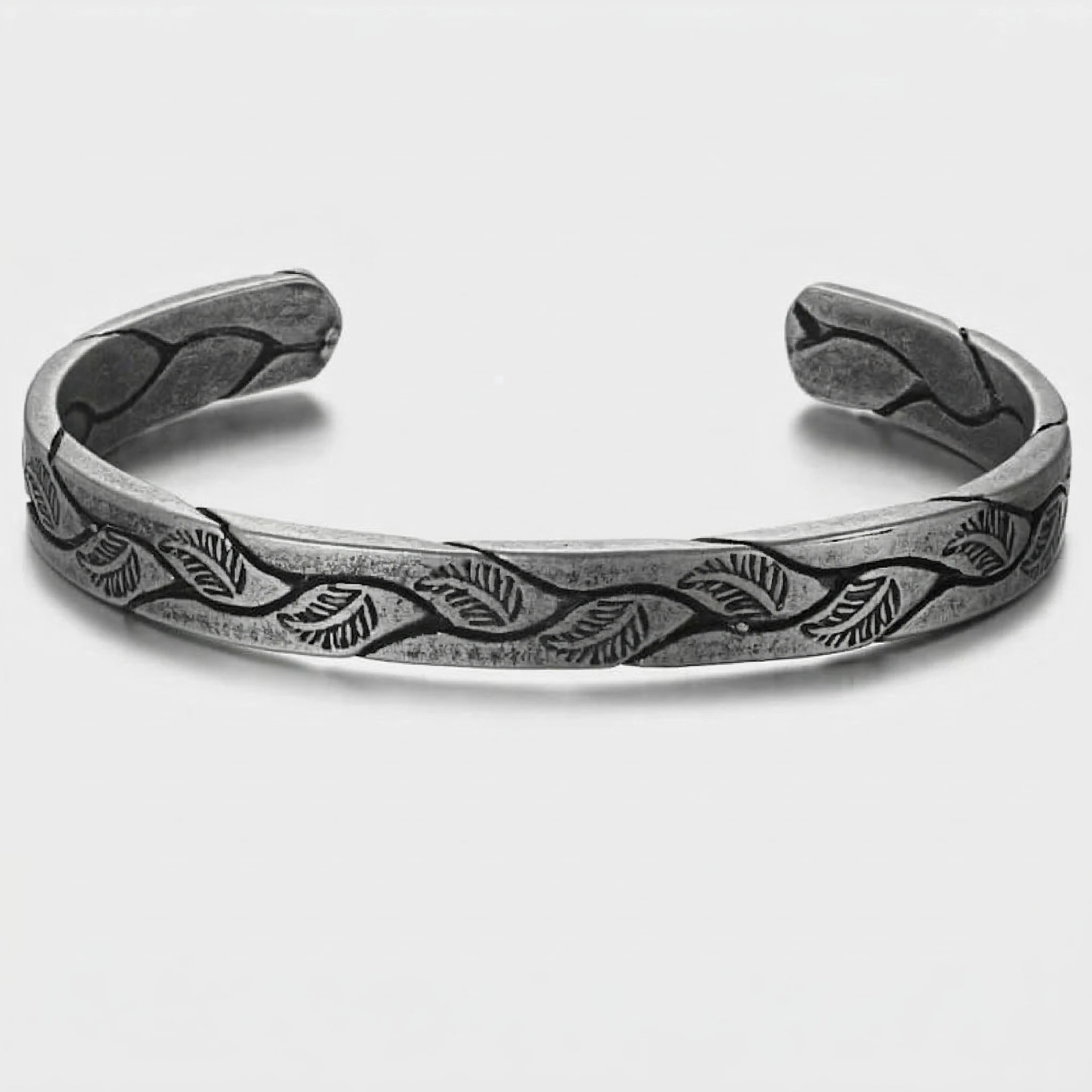 Silver bracelet with leaf pattern on a white background