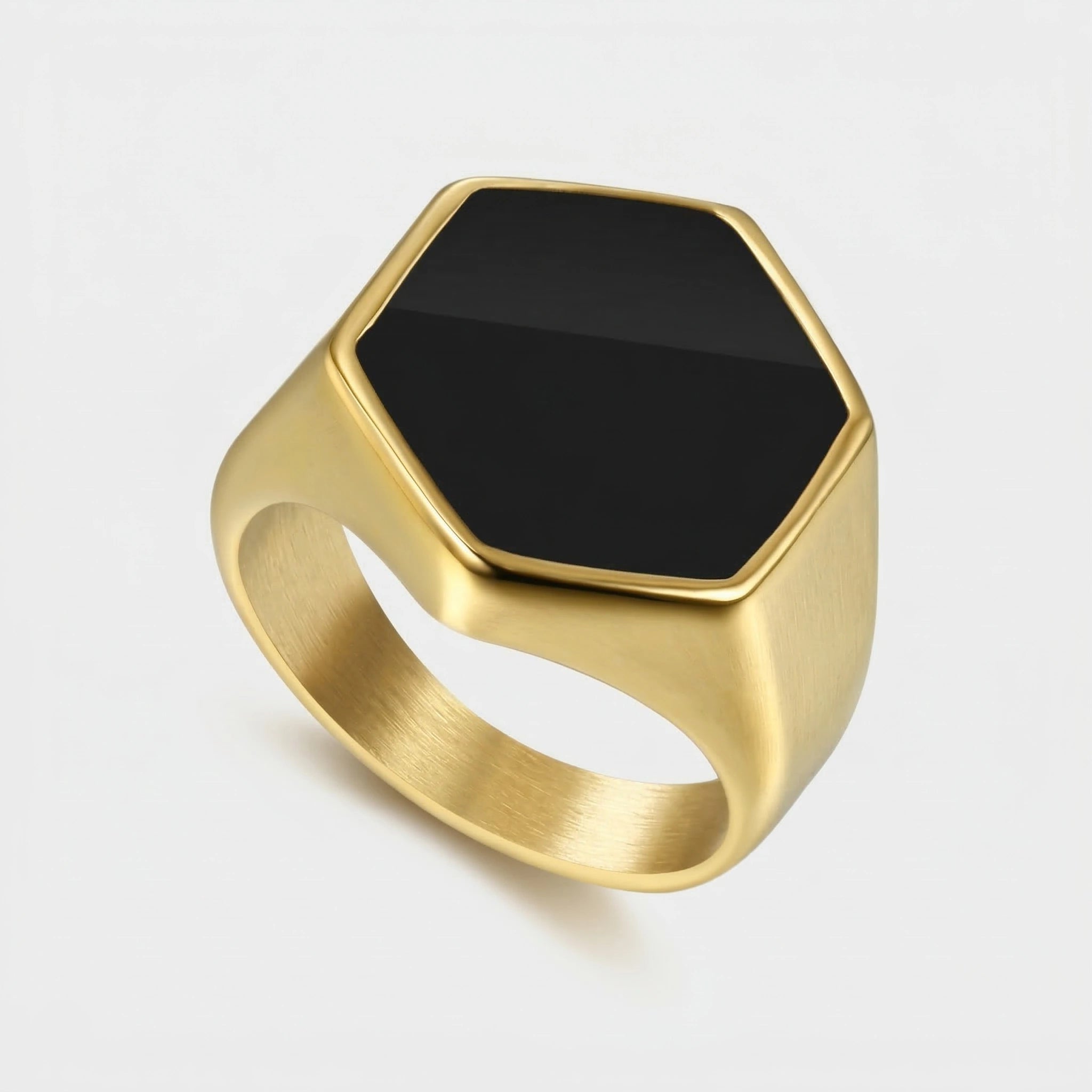 Gold ring with a black hexagonal stone on a white background