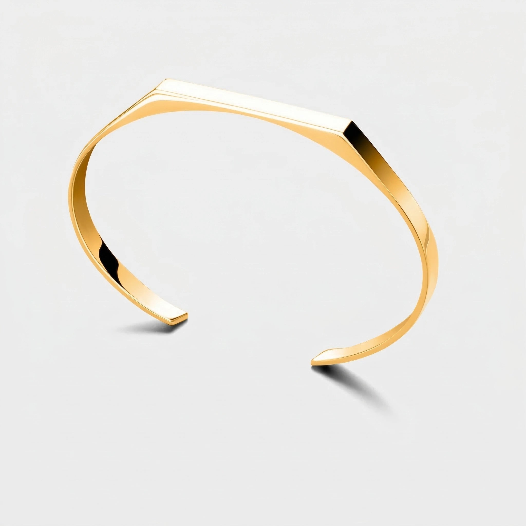 Gold rectangle cuff bracelet on a light gray background