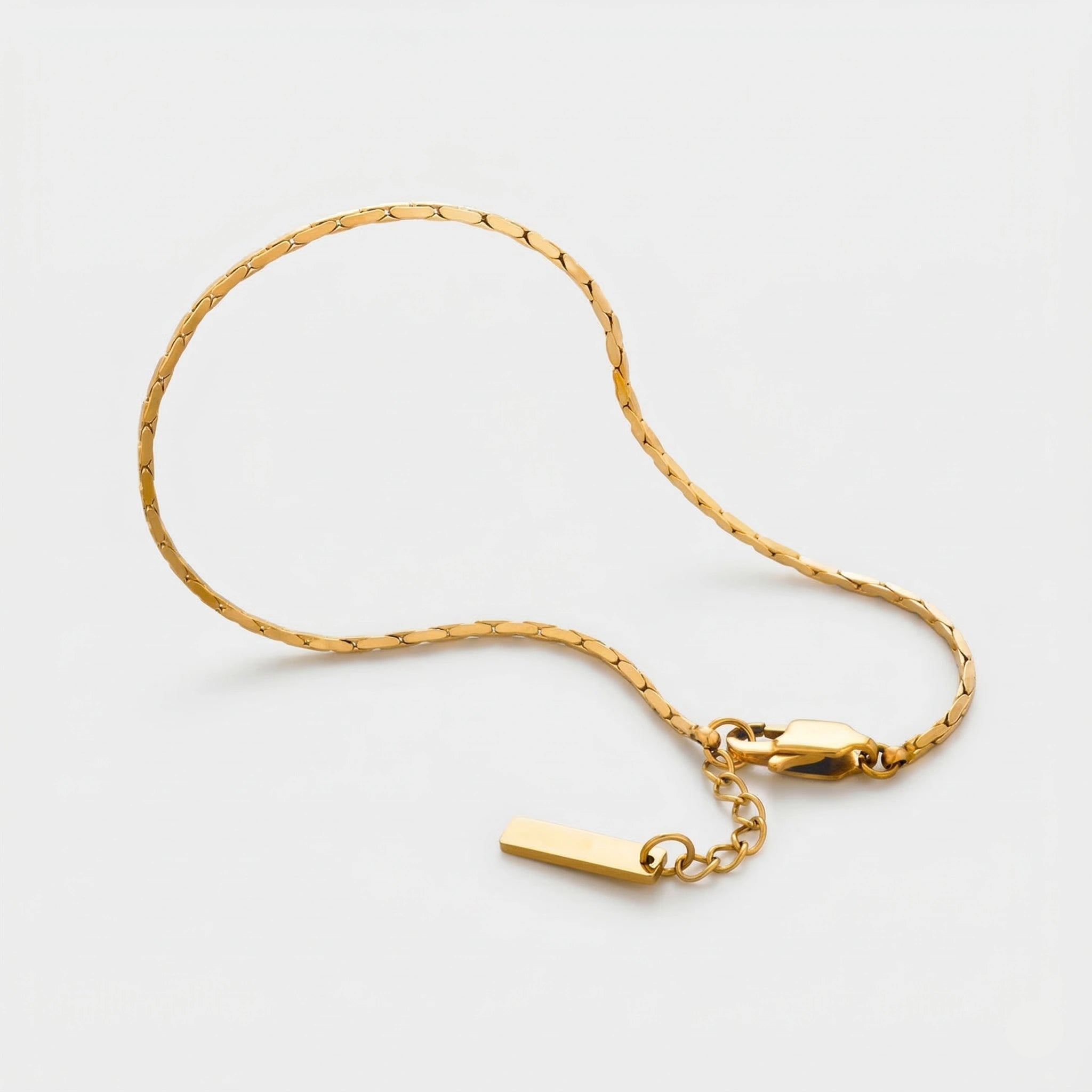 Gold wire bracelet on a light gray background